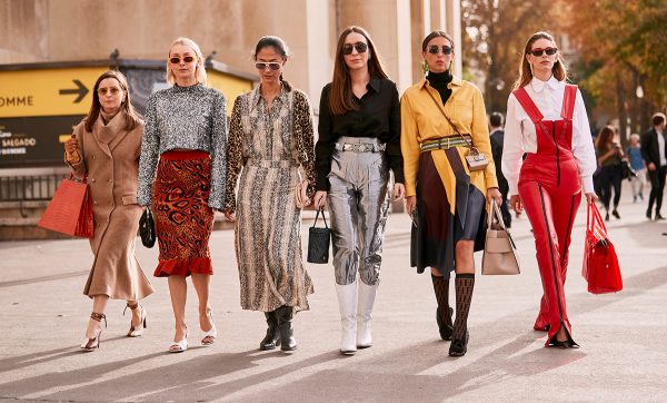 mujeres impulsando la moda, con trajes de diseñador.